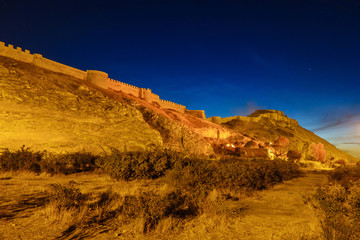 Fototapeta premium Panoramic night view onto Van Fortress, Van, Turkey. Castle & its walls lighted by night lights with golden colors. Van was founded in 9 century BC by Urartians. Fortress is main tourist sight of city