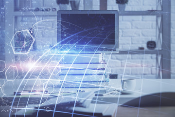 Double exposure of desktop with computer and world map hologram. International data network concept.
