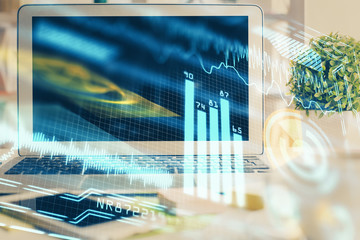 Computer on desktop in office with technology theme hologram. Double exposure. Tech concept.