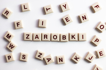 Słowo zarobki ułożone z literek na jasnym białym tle © andsko