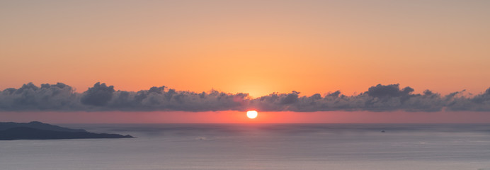 Puffy clouds and setting sun over the Mediterranean island of Corsica