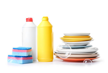 Clean tableware with sponges and detergents on white background