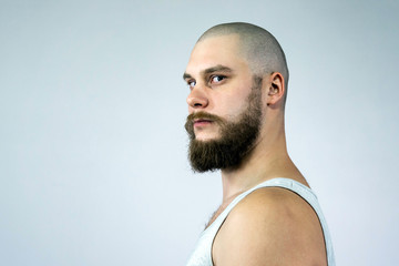 portrait of a confident bald guy with a beard, side view