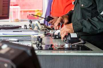 Closeup of captain's hands manipulating thruster control lever on the gridge of a tug boat