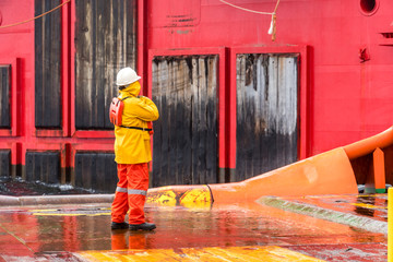 An Able-bodied seamen on anchor handling tug boat communicate with a work barge for receiving...