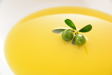 Dish filled with olive oil bathing an olive sprig
