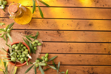 Olive oil on table with branches and olives top