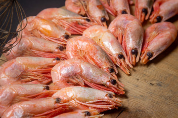 Boiled shrimp. Shrimps lie on a wooden board. Decorated around with dry greenery. Seafood