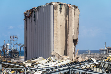 Aftermath of the Beirut port explosion, featuring a damaged grain silo, twisted metal structures,...