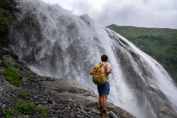 Naklejka premium Waterfall Landscape and male Traveler enjoying waterfall view.
