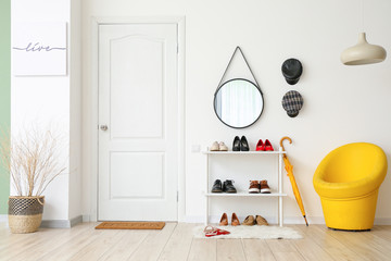 Stylish interior of modern hall with shoes on stand