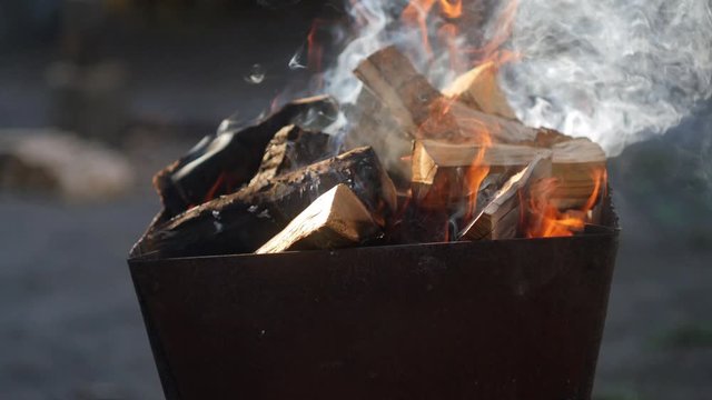Firewood burning in the brazier close up. Cooking outdoor. Family time picnic. Flame and smoke. 