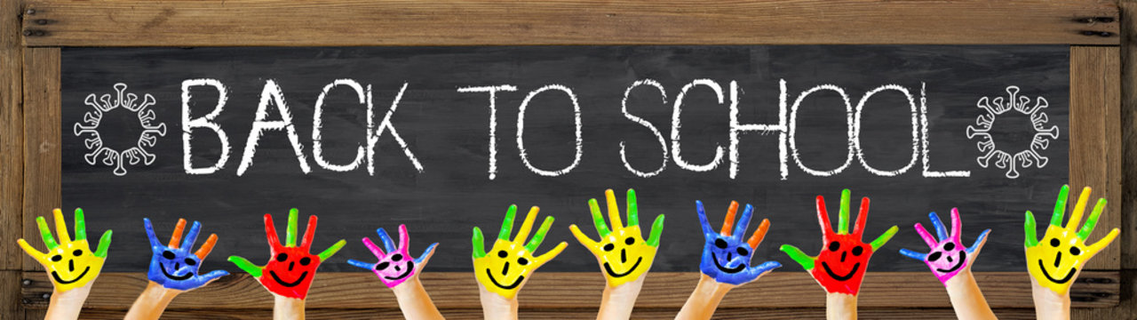 CORONAVIRUS / SCHOOL START, background, banner, panorama - Black anthracite school blackboard and wooden frame,  " welcome back to school " white handwriting font and virus symbol and colorful hands