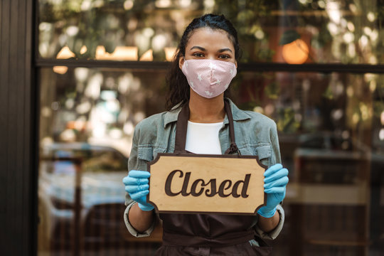 Woman Wearing Medical Face Mask Holding Closed Sign