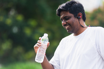 Close up Asian young sport runner black man wear athlete headphones he drinking water from a bottle...