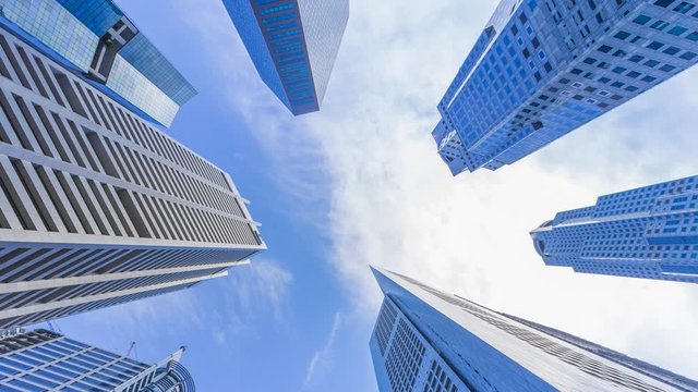 Footage 4k Timelapse, Looking up to Central Business District and downtown financial skyscraper buildings in Singapore with moving clouds and sun in the sky.