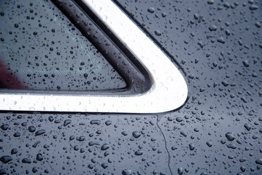 Water drops collect on top of metallic car surface