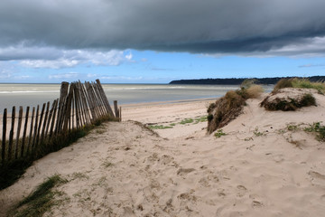 Fototapeta na wymiar Plage Dragey-Ronthon à marée basse sous un ciel nuageux