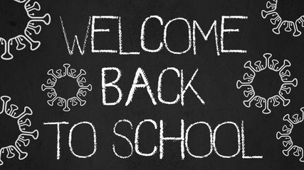 CORONAVIRUS / SCHOOL START background - Black anthracite school blackboard, with the words " welcome back to school " white handwriting font and virus symbol