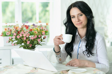 Portrait of beautiful young woman using modern laptop