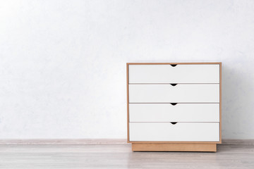 Modern chest of drawers near light wall in room