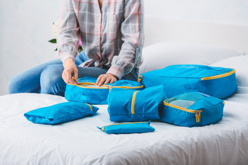 Woman packing clothes before journey at home