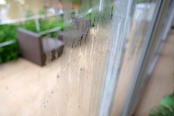 Rain drops on the glass window with cafe Background