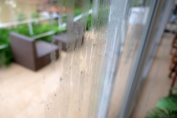 Rain drops on the glass window with cafe Background