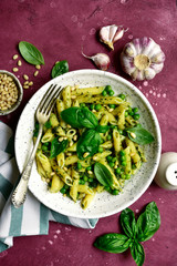 Penne pasta with green pea and basil pesto. Top view with copy space.