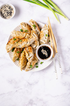 Fried dumplings gyoza with soy sauce, and chopsticks.