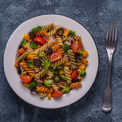 Pasta salad with tomato, broccoli, black olives.