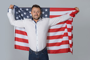 Handsome business man with the USA flag behind his back. Strong male American.