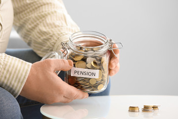 Senior man with savings in jar at home