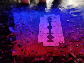 Water droplets on razor ( blade) with colourful lights