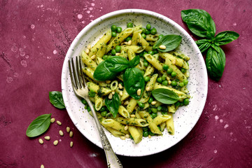 Penne pasta with green pea and basil pesto. Top view with copy space.
