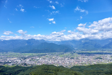 夏、鷹狩山展望台から北アルプス・大町市街を望む 長野県大町市