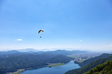 夏の木崎湖上空を滑空するパラグライダー 長野県大町市