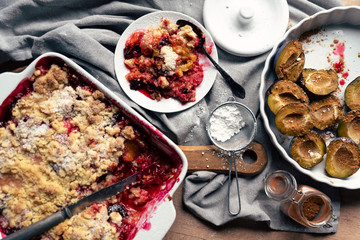 Homemade dessert with fruit. Plum as a ingredient in tasty meal in the summer. Vegetarian diet on the table in the kitchen. Close up and top view.