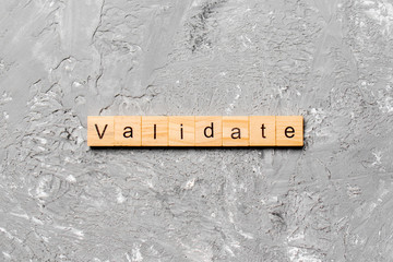 VALIDATE word written on wood block. VALIDATE text on cement table for your desing, concept