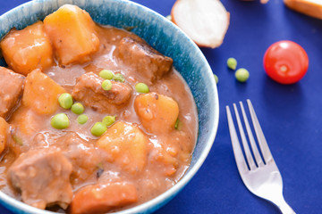 Bowl with tasty beef stew on table, closeup