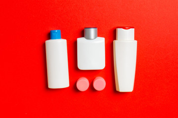 Cosmetics SPA branding mock-up, top view with copy space. set of tubes and jars of cream flat lay on colored background