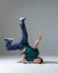 Cool guy breakdancer dancing on one hand isolated on gray background. Breakdance poster