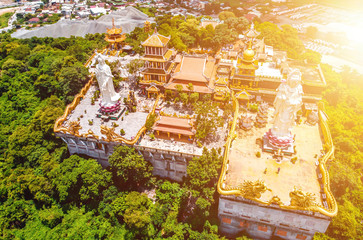 Obraz premium Aerial view of bodhisattva architecture and double sky dragon in Chau Thoi pagoda, Binh Duong province, Vietnam in the afternoon with sun through cloud create auspicious buddha.