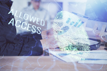 Fingerprint hologram with businessman working on computer on background. Security concept. Double exposure.