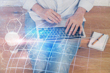 Double exposure of world map hologram with man working on computer on background. Concept of worldwideweb.