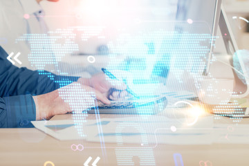 Double exposure of world map hologram with man working on computer on background. Concept of worldwideweb.