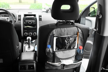 Travel organizer with different things on car seat in salon