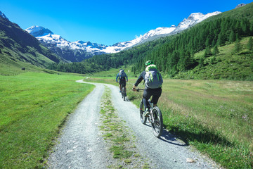 Fototapeta na wymiar Couple of friends cyclists with mountain bikes in the mountains in beautiful landscape on the alps