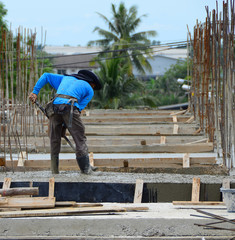 Construction workers are using the newly poured cement spreaders of crane into the ground to allow ordinary cement concrete with a thickness determined by the engineer and a smooth uniform surface.