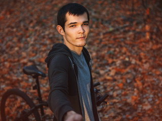 A man rides a Bicycle in the autumn forest in late October. Selfie portrait